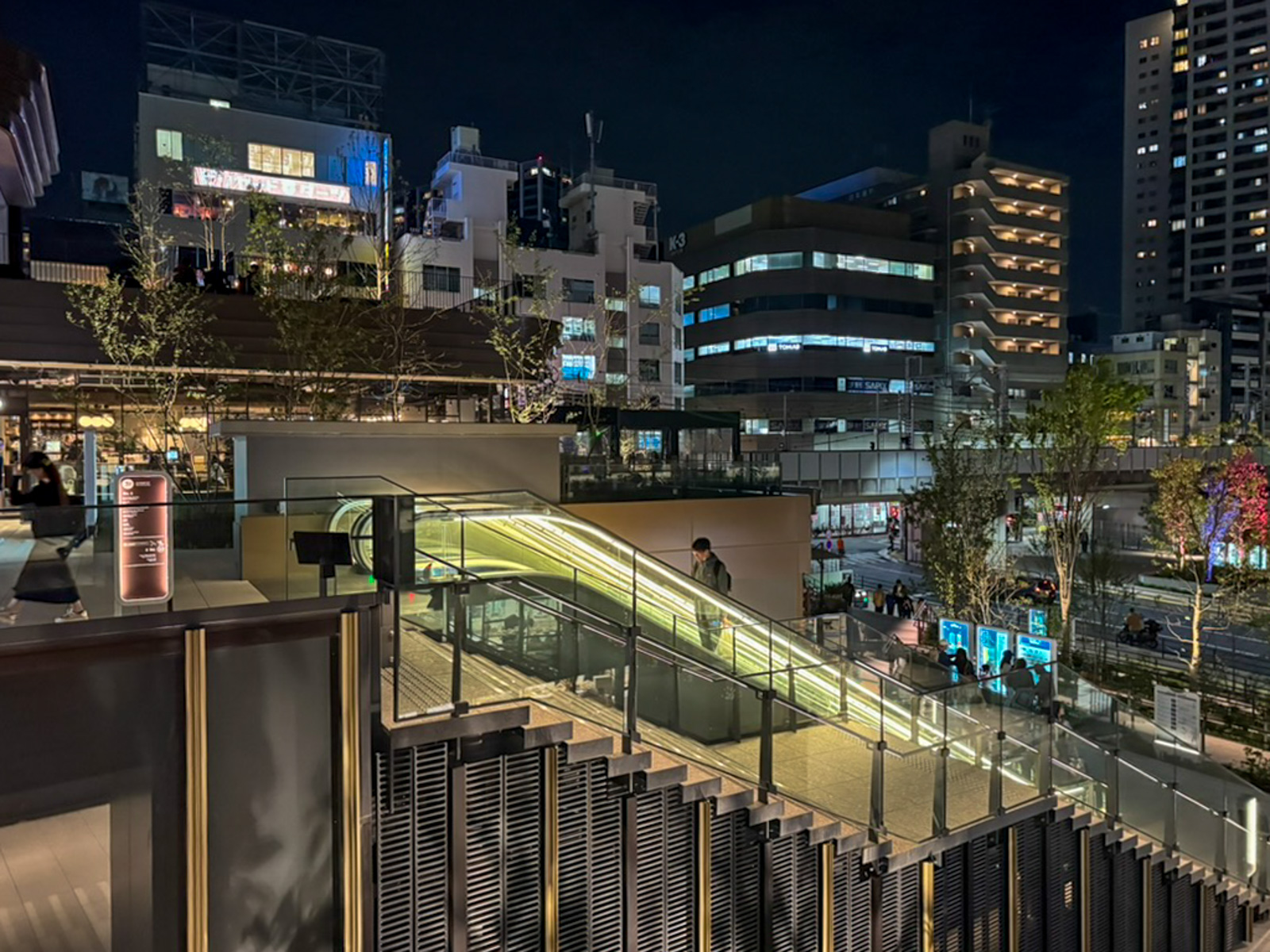 夜の外部テラスと階段。都市夜景を背景に複数の層が重なる