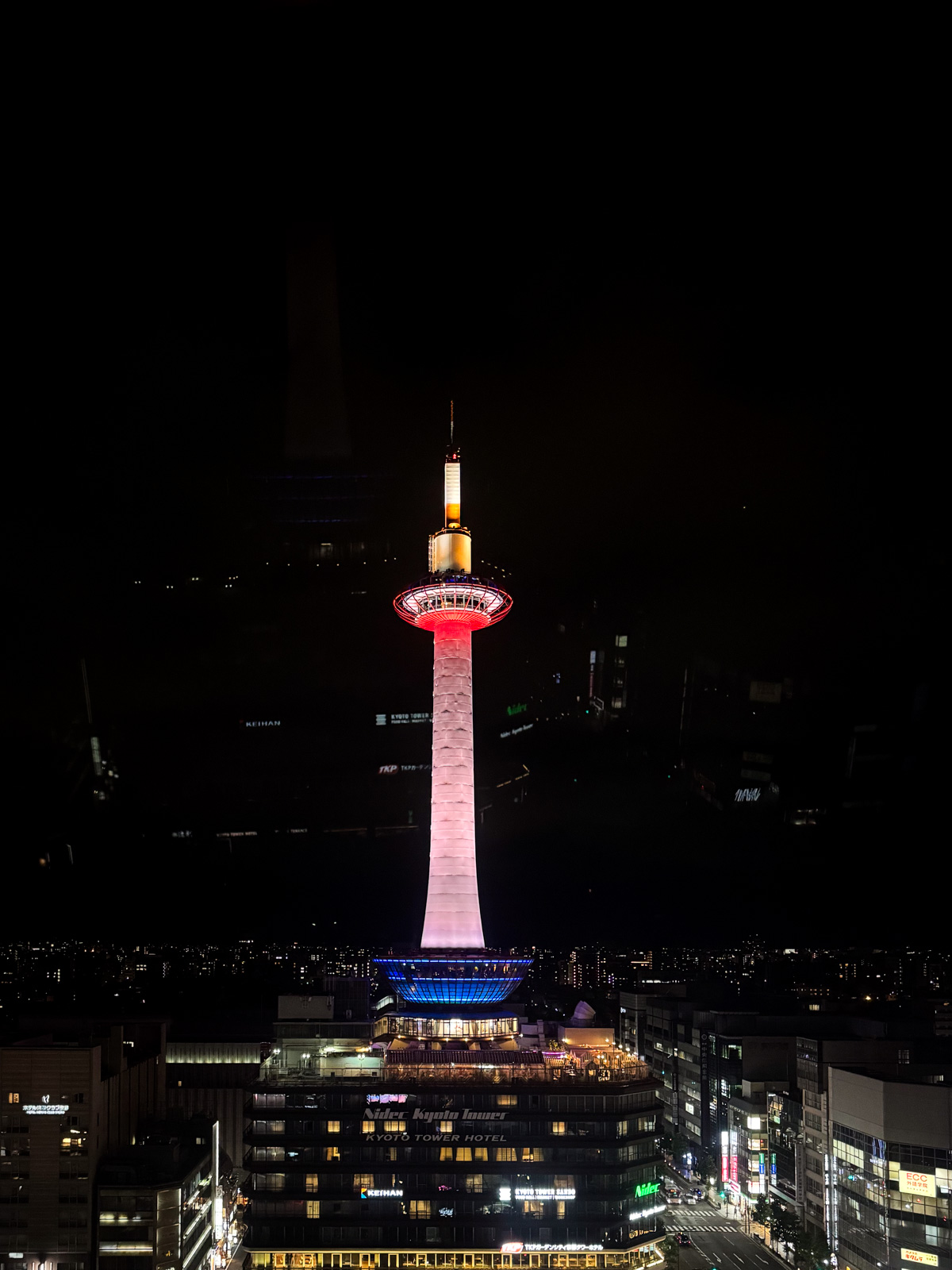 京都タワーの夜景。黒い空に赤いタワーが立つ