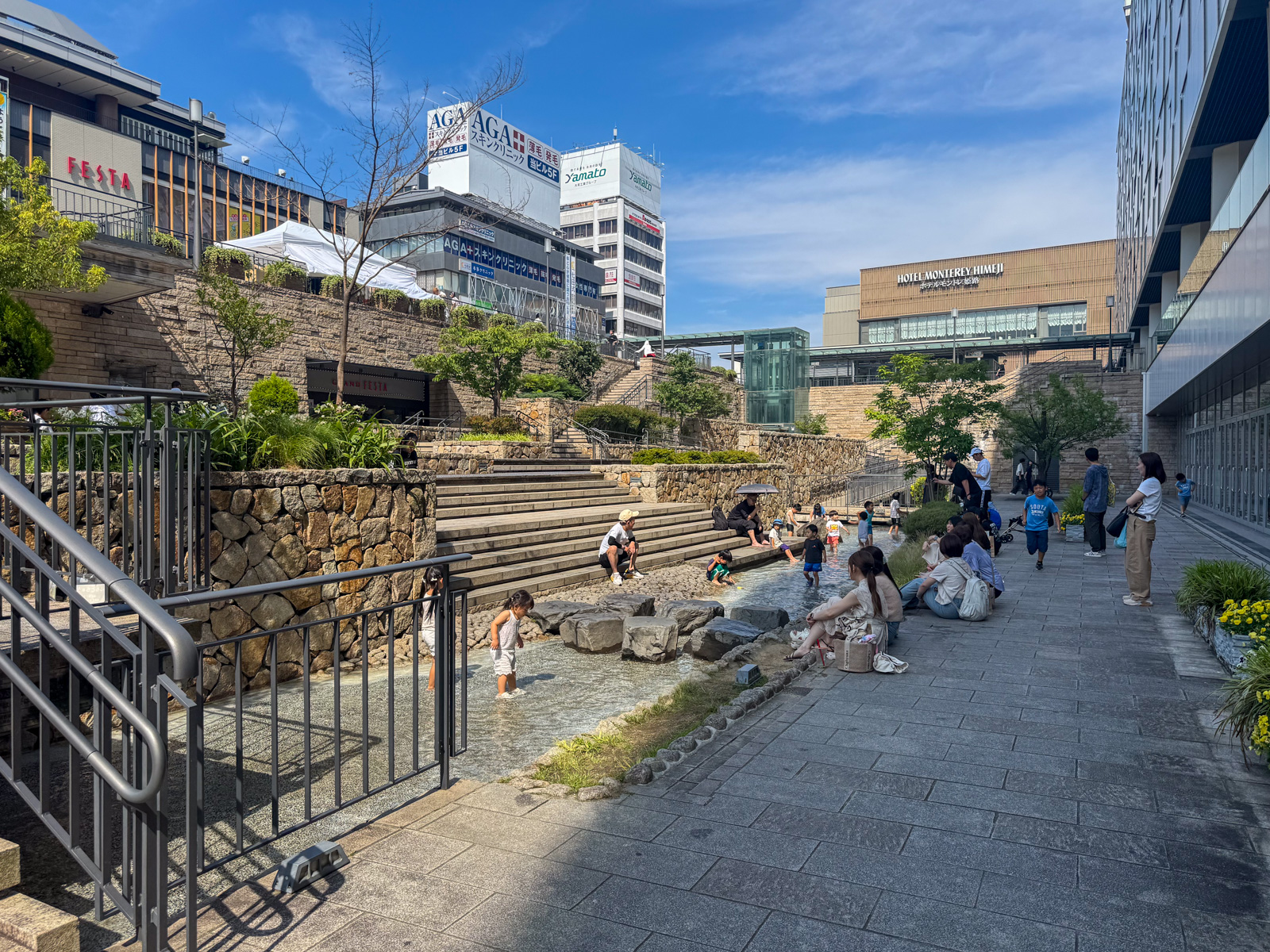 水遊びができる小川。子供たちが石の上に立って水に触れている